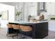 Modern kitchen features a black island with white countertops and three woven stools at 64 Telfair Ct, Acworth, GA 30101