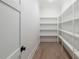 Walk-in pantry with white shelving, light wood floors and white walls at 64 Telfair Ct, Acworth, GA 30101