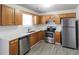 Well-lit kitchen with stainless steel appliances, light countertops, and classic wood cabinetry at 844 Glenshire Ct, Riverdale, GA 30274