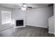 Bright living room featuring a fireplace, modern ceiling fan, and beautiful laminate wood flooring at 844 Glenshire Ct, Riverdale, GA 30274
