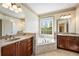 Bright bathroom featuring double vanity, soaking tub beneath a window, and marble countertops at 961 Persimmon Pt, Atlanta, GA 30328