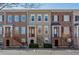 Exterior view of charming townhomes featuring brick and neutral siding with well-manicured landscaping at 961 Persimmon Pt, Atlanta, GA 30328