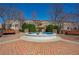 Community fountain surrounded by brick pavers and benches in front of townhomes on a clear, sunny day at 961 Persimmon Pt, Atlanta, GA 30328