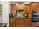 Close up of kitchen featuring stainless steel appliances, dark wood cabinets, and granite backsplash at 961 Persimmon Pt, Atlanta, GA 30328