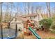 Charming backyard showcasing the home's garage, a playset, a trampoline, and a lush lawn at 345 W Spalding Dr, Sandy Springs, GA 30328
