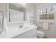 Bathroom featuring neutral patterned walls, white cabinets and fixtures, and a window with natural light at 345 W Spalding Dr, Sandy Springs, GA 30328