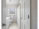 Neutral bathroom with patterned wallpaper and floors, plus white cabinets, trim and fixtures at 345 W Spalding Dr, Sandy Springs, GA 30328