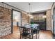 Unique dining room with brick accent wall and view into modern, light kitchen at 345 W Spalding Dr, Sandy Springs, GA 30328