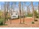 Charming two-story home with classic blue shutters surrounded by a wooded landscape and lovely front lawn at 345 W Spalding Dr, Atlanta, GA 30328