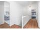 Bright hallway with hardwood floors and white railing, leading to bedrooms and living spaces at 345 W Spalding Dr, Sandy Springs, GA 30328