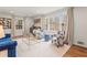 Bright living room featuring a blue sofa, patterned chairs, large windows, and elegant decor at 345 W Spalding Dr, Sandy Springs, GA 30328