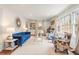 Bright living room featuring a blue sofa, patterned chairs, large windows, and elegant decor at 345 W Spalding Dr, Sandy Springs, GA 30328