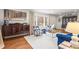 Bright living room featuring a blue sofa, patterned chairs, large windows, hardwood floors, and elegant decor at 345 W Spalding Dr, Sandy Springs, GA 30328