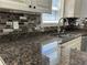 Close up of kitchen featuring granite countertops, mosaic backsplash, and a stainless steel faucet at 3559 Sawmill Ter, Marietta, GA 30062