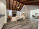 Bright living room features a wood beamed ceiling, stone fireplace, and an adjacent dining area at 3559 Sawmill Ter, Marietta, GA 30062