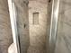 This glass shower features white marble tile, built in shelving, and modern shower head at 3559 Sawmill Ter, Marietta, GA 30062