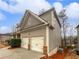 Side view of a two car garage and vinyl siding on a two-story home with a driveway and landscaping at 4963 Arbor View Nw Pkwy, Acworth, GA 30101