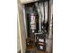 A cramped utility closet with a gray water heater and dark gray Goodman HVAC unit with silver piping at 740 Kibbe Cir, Lawrenceville, GA 30044