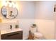 Well-lit half bathroom with modern vanity, decorative mirror, and neutral decor at 762 Thompson Ln, Loganville, GA 30052