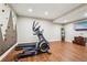 Finished basement featuring exercise equipment, climbing wall and a flatscreen tv at 10235 Worthington Mnr, Suwanee, GA 30024