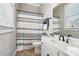 Cozy bathroom with a white vanity, neutral tile flooring, and a shower featuring a striped curtain at 10235 Worthington Mnr, Suwanee, GA 30024