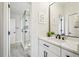 Bright bathroom featuring a white vanity, quartz countertop, and a walk-in shower with stylish herringbone tile at 10235 Worthington Mnr, Suwanee, GA 30024