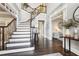 Grand foyer featuring a sweeping staircase and hardwood floors at 10235 Worthington Mnr, Suwanee, GA 30024