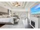 Bright main bedroom featuring a trey ceiling, hardwood floors, fireplace, and a seating area with natural light at 10235 Worthington Mnr, Suwanee, GA 30024