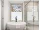 Spa-like bathroom showcasing a freestanding tub, sleek fixtures, and a window offering natural light at 1055 Ormewood Se Ave, Atlanta, GA 30316