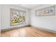 Bedroom featuring hardwood floors, white walls, and large window views of the neighborhood at 1055 Ormewood Se Ave, Atlanta, GA 30316