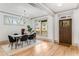 Sunlit dining area features modern chandelier, wood table, and stylish chairs adjacent to the front entrance at 1055 Ormewood Se Ave, Atlanta, GA 30316