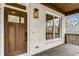 Close up of a cozy front porch with a wooden door, brick wall, and dark stained porch flooring at 1055 Ormewood Se Ave, Atlanta, GA 30316