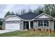 Charming brick home featuring a two-car garage, landscaped front yard, and covered entrance at 113 Scarlett Place Dr, Bowdon, GA 30108