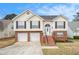 Charming split-level home featuring a brick facade, attached two-car garage, and a welcoming front entrance with stairs at 1947 Phillips Lake Blf, Lithonia, GA 30058