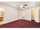 This main bedroom has red carpet, a ceiling fan and walk-in closet at 1947 Phillips Lake Blf, Lithonia, GA 30058