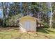 Charming backyard shed providing additional storage space, blending functionality with the natural landscape at 1947 Phillips Lake Blf, Lithonia, GA 30058