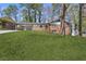 Charming brick home with a vibrant blue front door and a lush, green lawn at 5277 Cardinal Nw Ln, Lilburn, GA 30047