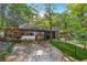 Stone driveway leading to a charming home with covered parking, surrounded by lush greenery and mature trees at 80 Rountree Rd, Riverdale, GA 30274