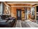 Living room with wood paneled walls, hardwood floors, leather reclining couches and decorative accents at 80 Rountree Rd, Riverdale, GA 30274