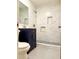 Updated bathroom with marble shower, dark vanity, and neutral-colored hexagon tile at 1332 Willis Mill Sw Rd, Atlanta, GA 30311