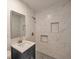 Updated bathroom features tile shower with built-in niche, modern vanity, and mosaic tile floor at 1332 Willis Mill Sw Rd, Atlanta, GA 30311