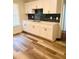 Bright kitchen featuring white cabinetry, granite counters, dark backsplash, and hardwood flooring at 1332 Willis Mill Sw Rd, Atlanta, GA 30311