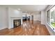 Open living room showcasing a fireplace and hardwood floors leading to a modern kitchen and large windows at 1332 Willis Mill Sw Rd, Atlanta, GA 30311