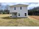 View of the backyard, showcasing the home's siding, covered patio, and newly seeded lawn at 145 Scarlett Place Dr, Bowdon, GA 30108