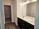 Bathroom featuring double sink vanity, dark wood cabinets, quartz countertops, and a linen closet at 145 Scarlett Place Dr, Bowdon, GA 30108