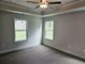 Bright bedroom with neutral walls, carpeted floors, a tray ceiling, and large windows overlooking a backyard at 145 Scarlett Place Dr, Bowdon, GA 30108