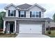 Charming two-story home featuring gray siding, brick accents, black shutters, and a two-car garage at 145 Scarlett Place Dr, Bowdon, GA 30108