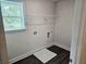 Convenient laundry room with hookups, overhead shelving, and ample natural light from the window at 145 Scarlett Place Dr, Bowdon, GA 30108