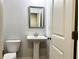 Powder room featuring pedestal sink, square mirror, and chrome hardware at 3275 Wild Basil Ln, Buford, GA 30519