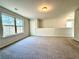 Carpeted room with a large window bringing the outside in and neutral walls at 3275 Wild Basil Ln, Buford, GA 30519